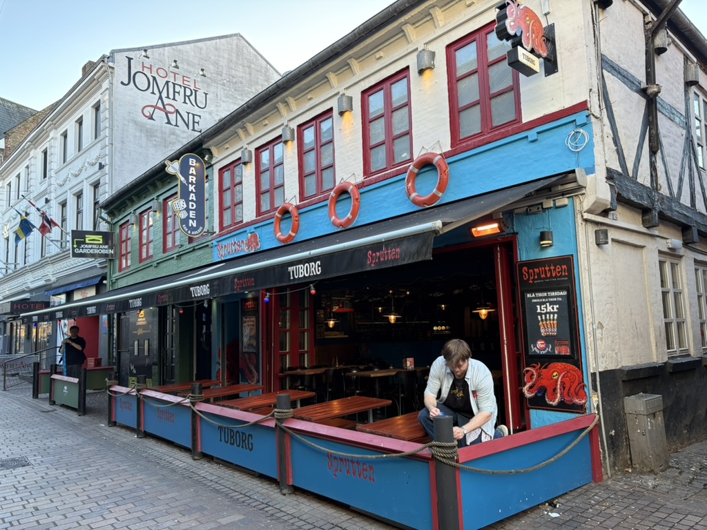Sprutten i Jomfru Ane Gade i Aalborg med maritim facade, redningskranse, udendørs siddepladser og Tuborg-markiser.